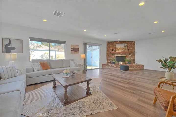 Spacious family room with corner brick fireplace and recessed lighting
