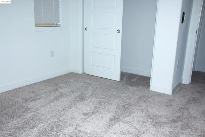 Unfurnished bedroom featuring carpet and baseboards