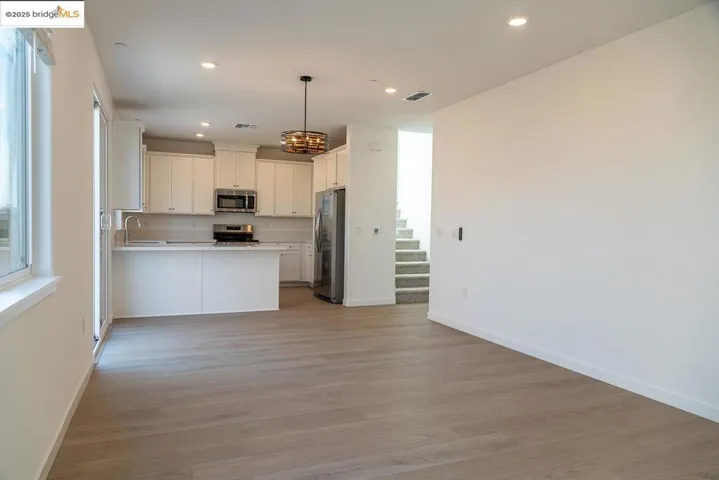 Kitchen with open floor plan, recessed lighting, light wood-style flooring, light countertops, and stainless steel appliances