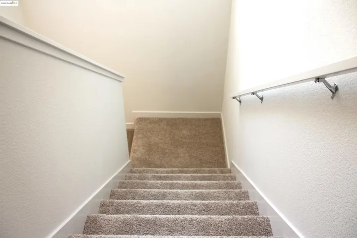 Stairway with a textured wall and carpet