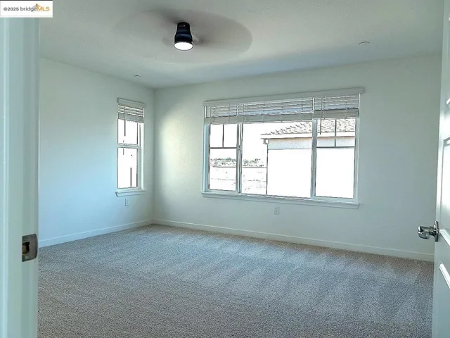 Carpeted spare room featuring baseboards