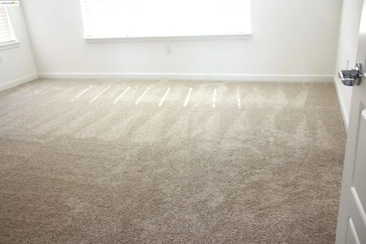 Carpeted spare room featuring healthy amount of natural light