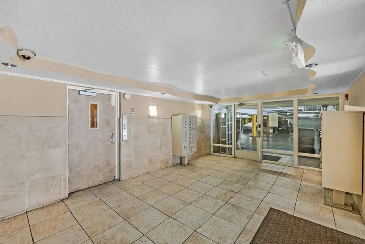Empty room featuring a textured ceiling and tile walls
