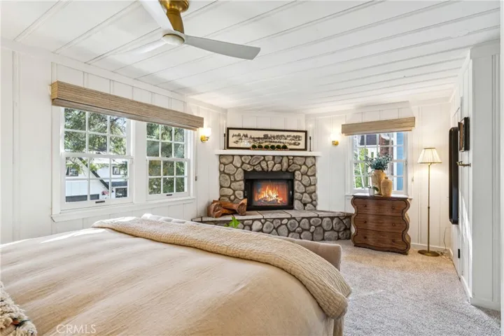 Primary ensuite bedroom iwth walk in closet it fireplace (fire is enhanced in photo)