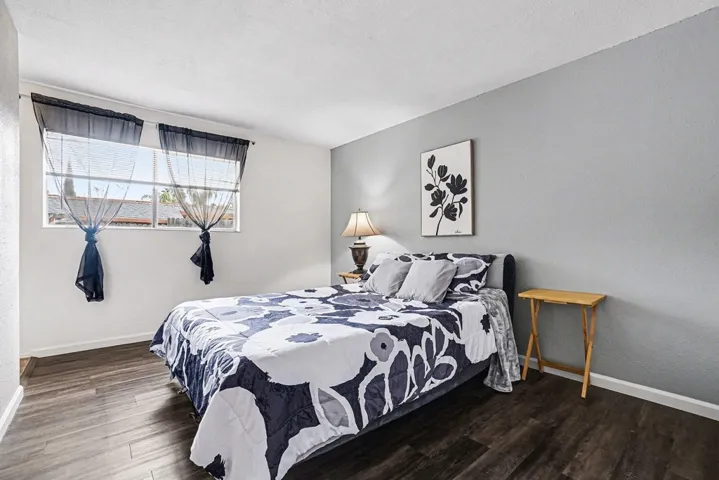 Bedroom with baseboards and dark wood-style flooring
