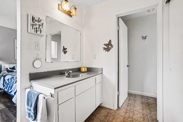 Ensuite bathroom with vanity and a textured wall