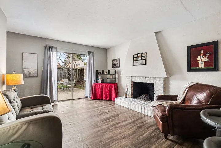 Living room with a brick fireplace and wood finished floors