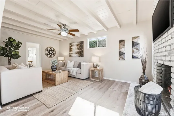 Family room with wood burning fireplace, ceiling fan, and NEW paint and flooring!