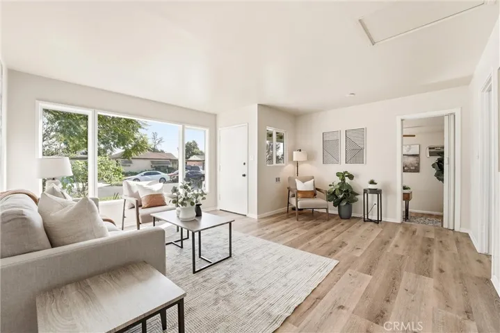 Living room with large windows overlooking the lushly landscaped front yard!