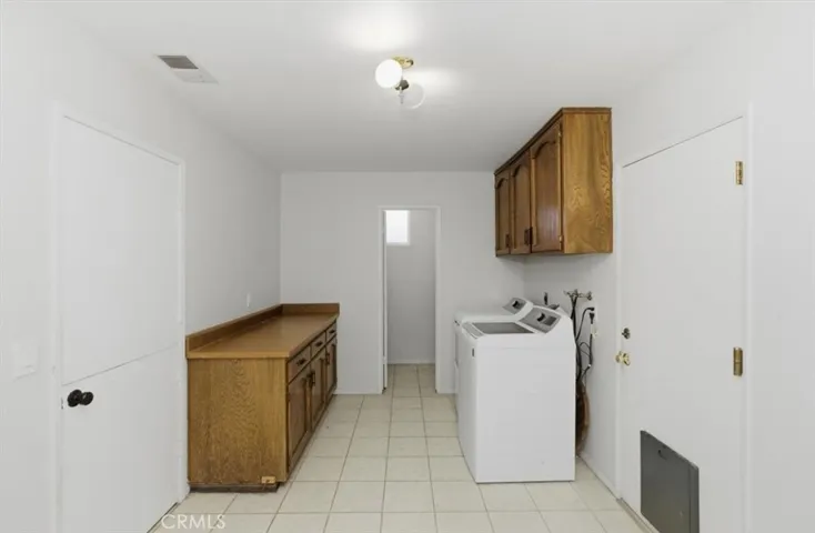 oversized laundry room with cabinets and a guest bathroom