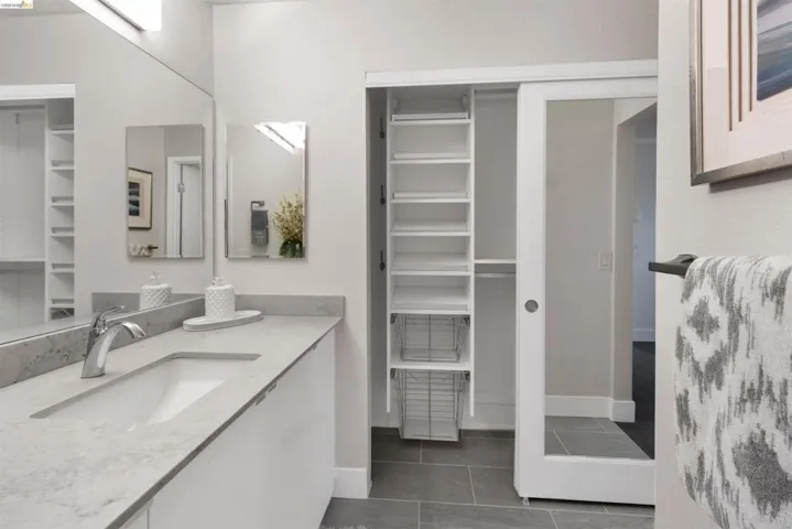 Bathroom featuring California closet, vanity, and tile  flooring