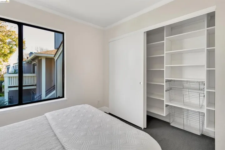 Bedroom featuring crown molding and a spacious closet