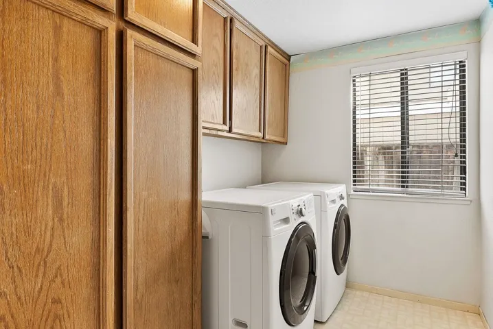 Laundry room featuring light floors, cabinet space, and independent washer and dryer
