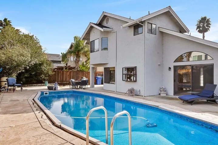View of swimming pool with patio surround and outdoor dining area