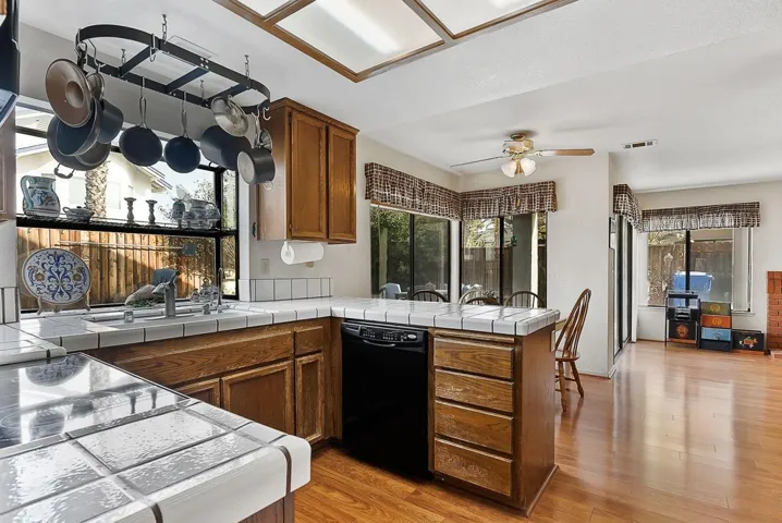 Kitchen with a peninsula, tile counters, and wood finish cabinets