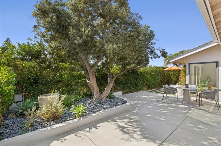 Spacious backyard patio surrounded by mature landscaping, ideal for outdoor lounging and entertaining.
