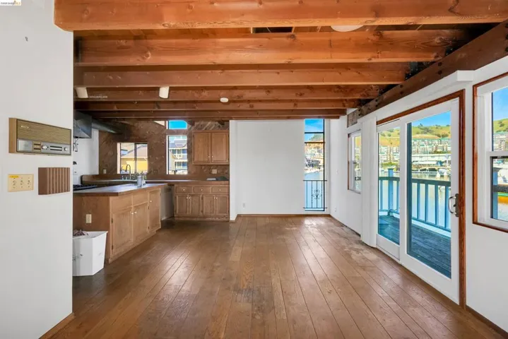 Kitchen featuring dark wood-style flooring, wood finish cabinets, and dark countertops