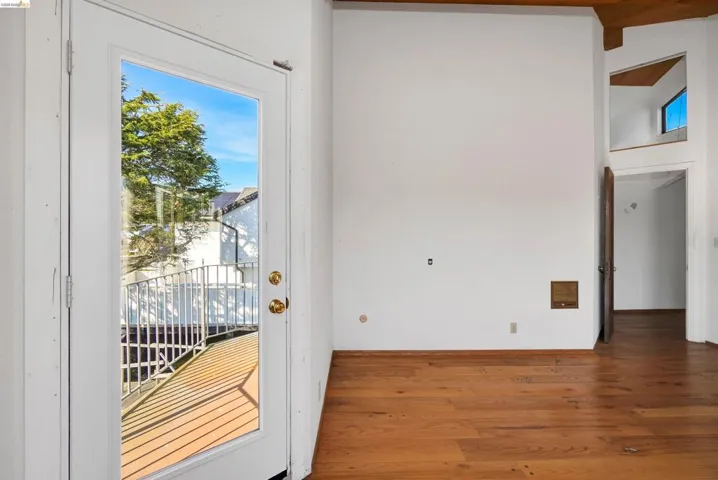 Entryway with wood finished floors and beam ceiling