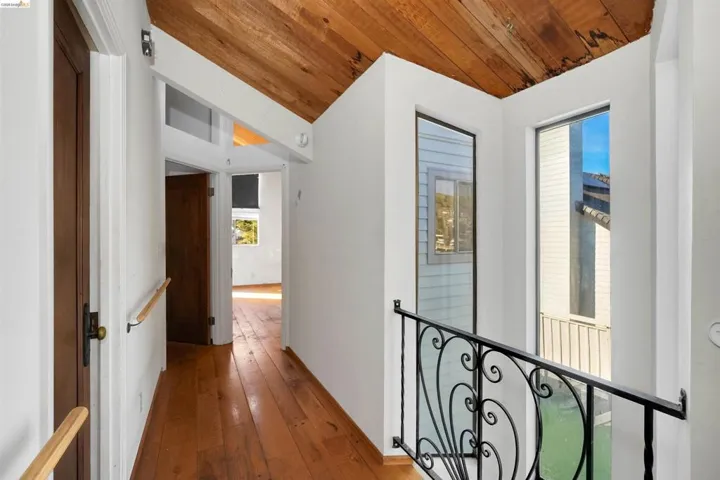 Hallway with hardwood / wood-style flooring and a vaulted wooden ceiling