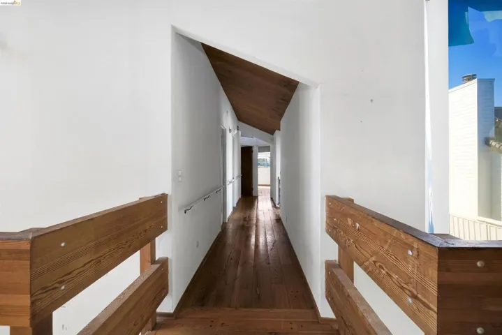 Hallway featuring dark wood-style flooring and a vaulted wood ceiling