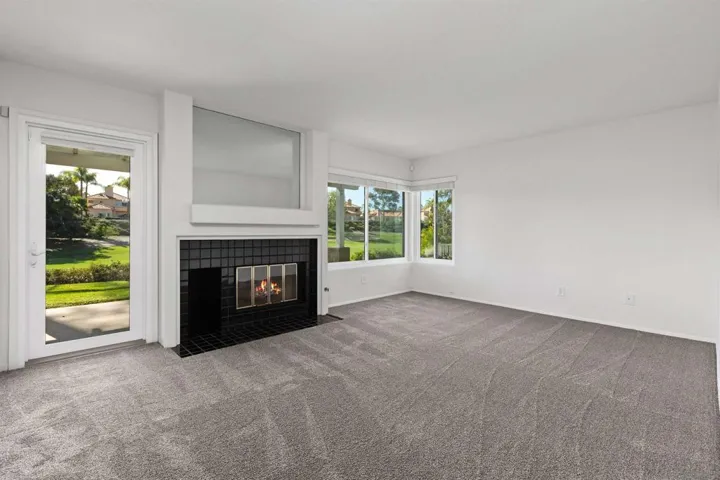 Living room with fireplace and golf course views.