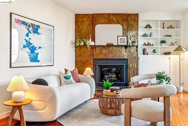 Kitchen featuring a breakfast bar, hanging light fixtures, an island with sink, stainless steel appliances, and tasteful backsplash
