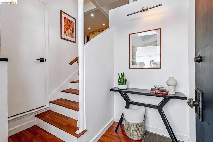 Staircase with wood finished floors and recessed lighting