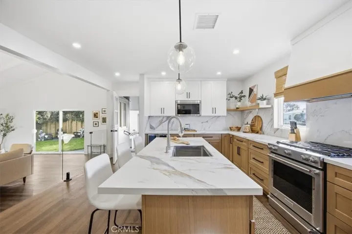Large, updated kitchen open to living area, dutch door to back patio/bar area