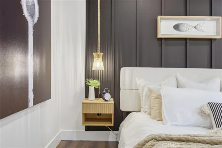 Primary bedroom with detailed wood paneling, walk-in closet and en suite bath