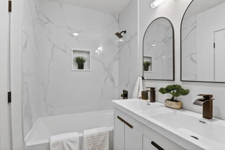 Bathroom featuring double vanity and bathtub / shower combination