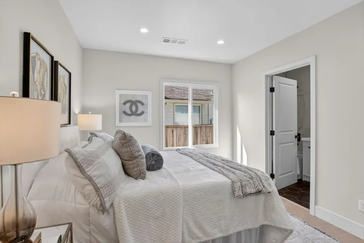 Bedroom with ensuite bath, wood finished floors, and recessed lighting