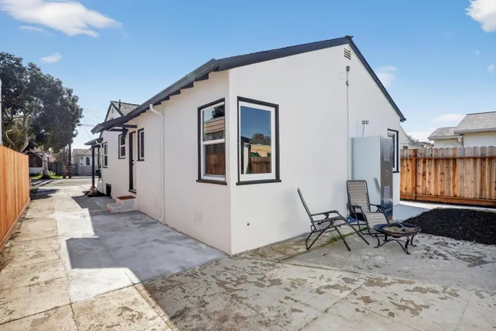 View of side of home featuring stucco siding and a patio