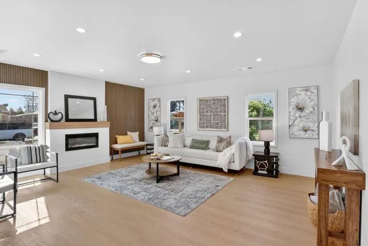 Living room featuring a glass covered fireplace, light wood-style floors, and recessed lighting