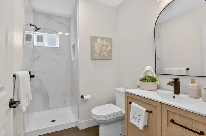 Full bathroom with vanity and a marble finish shower