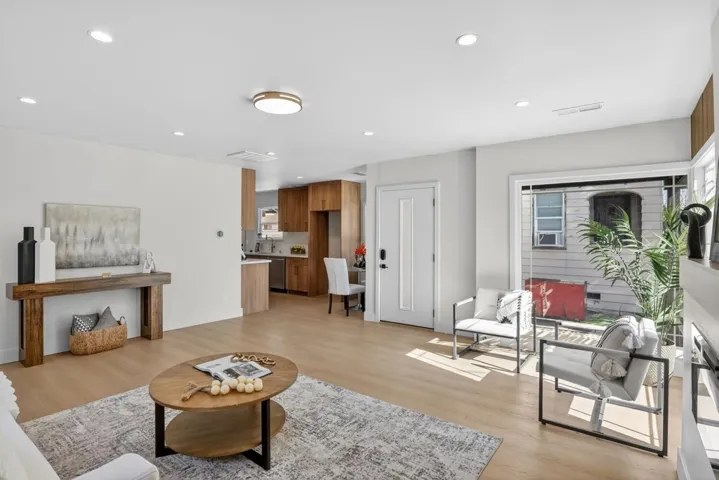 Living area with light wood-style floors and recessed lighting