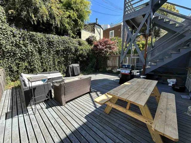 Wooden deck featuring outdoor lounge area, a fenced backyard, and grilling area