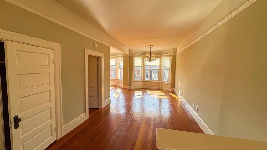 Unfurnished dining area with hanging lights and hardwood / wood-style flooring