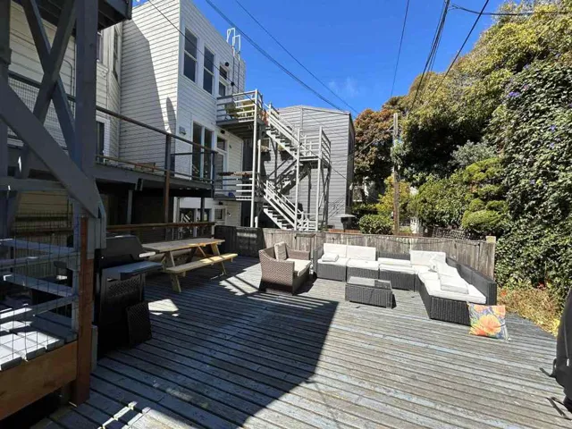 Wooden terrace with an outdoor living / dining area and stairway