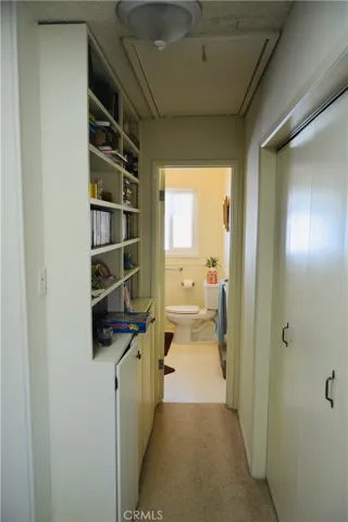 main level built in bookcase leads to bathroom