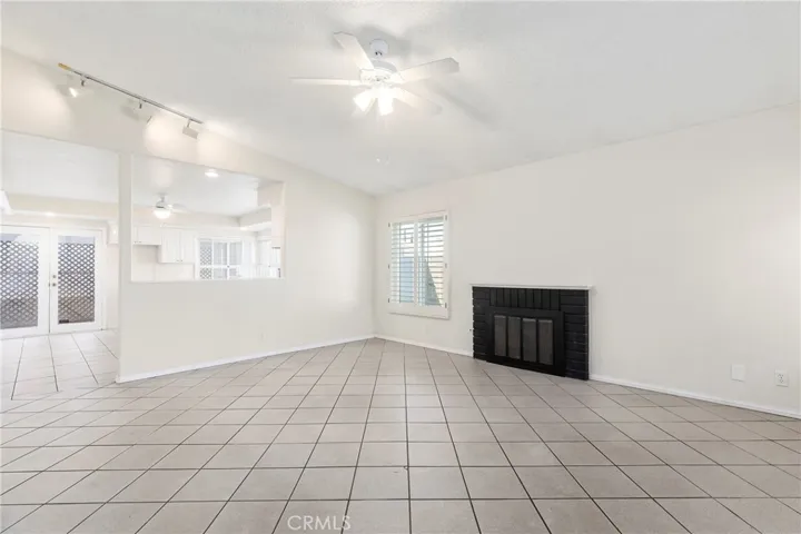 Living room with gas fireplace, vaulted ceiling, and open to kitchen