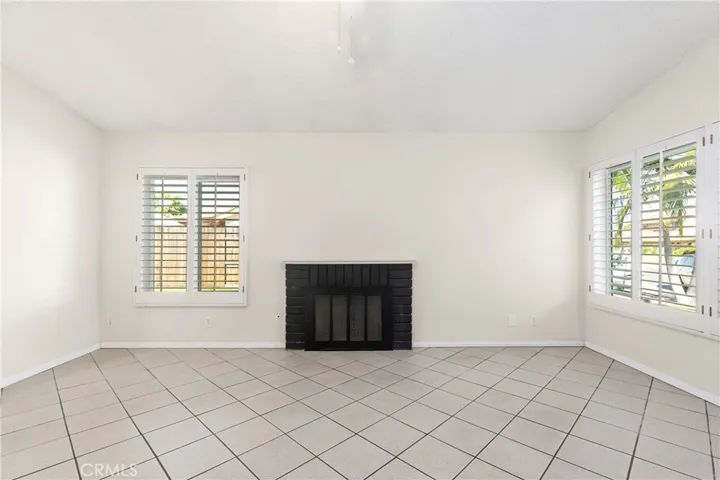 Living room with gas fireplace, vaulted ceiling, and open to kitchen