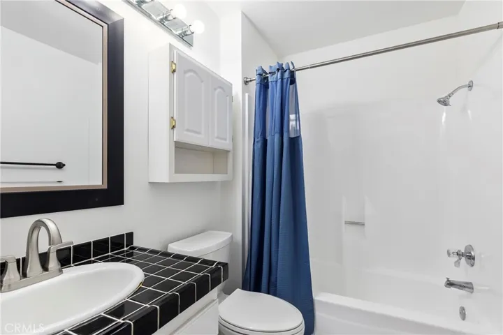 Secondary bathroom with shower in tub.