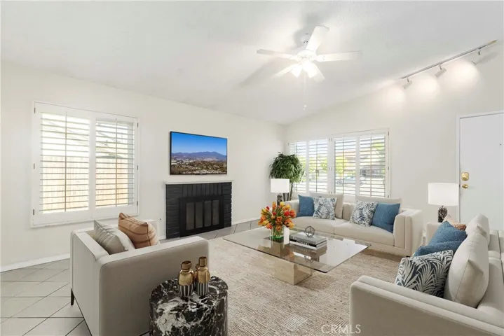 Living room with gas fireplace, vaulted ceiling, and open to kitchen(virtual staging)