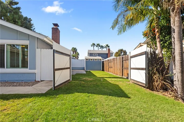 View of front and side yard with gate open