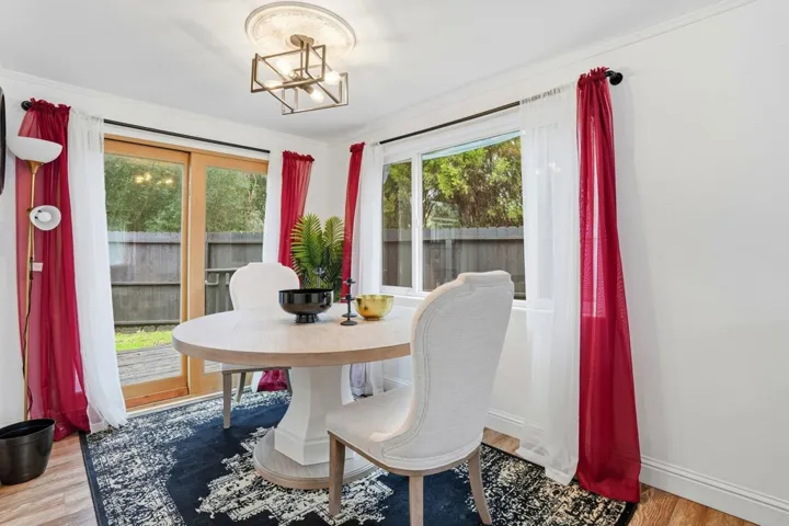 Dining room featuring hanging lights, light wood finished floors, and crown molding