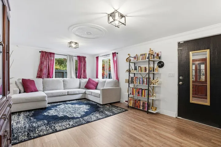 Living area with crown molding and light wood-type flooring