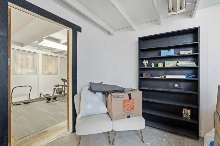 Living area featuring beamed ceiling and concrete floors