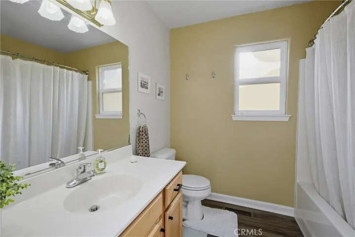 Hall bath with shower over tub and large vanity.