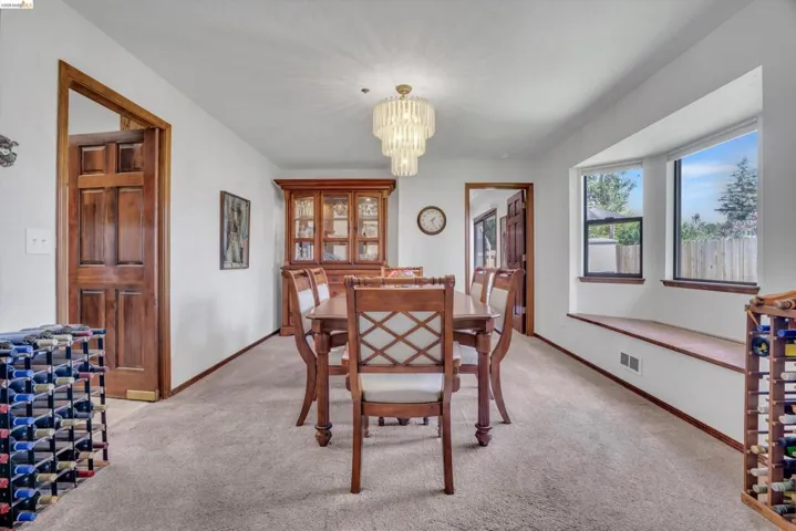 Dining area with a chandelier and light colored carpet