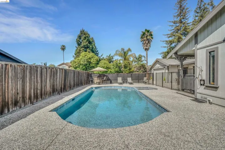 View of swimming pool featuring patio surround and a fenced backyard